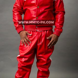 Pu&ograve; includere: Completo giacca e pantaloni in pelle rossa con strisce e dettagli bianchi. La giacca ha uno stile bomber con colletto e polsini a coste. I pantaloni hanno una vita con coulisse e polsini a coste. Il sito web www.mmtc-pk.com &egrave; visibile.