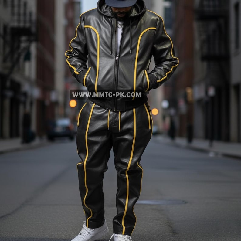May include: Black leather tracksuit with yellow trim. The jacket has a hood and a zipper closure. The pants have a matching yellow stripe down the sides. The website address www.mmtc-pk.com is visible on the jacket.
