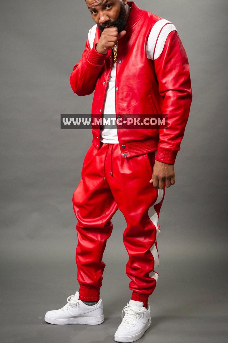 Pu&ograve; includere: Giacca in pelle rossa con strisce bianche sulle spalle e pantaloni in pelle rossi abbinati con strisce bianche laterali. L'outfit &egrave; abbinato a scarpe da ginnastica bianche. L'indirizzo del sito web "WWW.MMTC-PK.COM" &egrave; visibile.