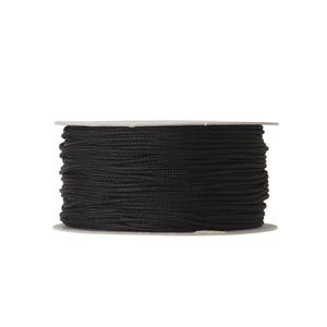May include: A spool of black cord wrapped tightly around a cylindrical cardboard core. The cord is thin, smooth, and uniform in texture, wound in multiple horizontal layers that cover the entire surface of the spool from top to bottom.