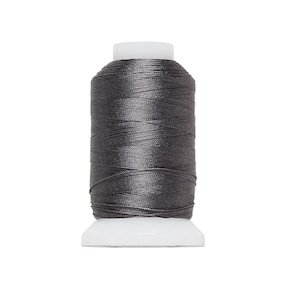 May include: A spool of dark gray thread, tightly wound around a white plastic base. The thread has a slight sheen, suggesting a smooth texture. Ideal for sewing, embroidery, or other textile crafts.