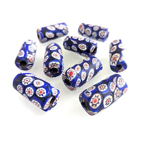 May include: A collection of blue, white, red, and black glass beads. The cylindrical beads feature a floral pattern with a dark blue base and are suitable for jewelry making or crafts.
