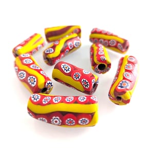 Peut inclure: Un ensemble de perles de verre cylindriques colorées. Les perles présentent un motif vibrant avec des motifs floraux rouges, jaunes et bleus. Les perles mesurent environ 2,5 cm de long, parfaites pour la fabrication de bijoux ou l'artisanat.