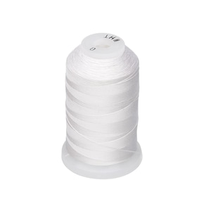 May include: A spool of white thread, labeled "WHT" and "0" on the top, is tightly wound around a cylindrical core. The thread is a bright white color, and the spool sits on a clear, circular base. Ideal for sewing and crafting projects.