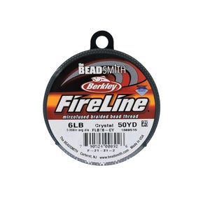 May include: A spool of gray FireLine microfused braided bead thread by Berkley Beadsmith. The spool is labeled with the text "6LB", "Crystal", "50YD", "FLBT6-CY", and "1389515".