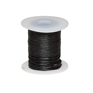 May include: A spool of black leather cord wrapped around a white plastic cylinder. The cord is thin, round, and tightly coiled in multiple layers around the centre of the spool, which features flat, circular white ends at the top and bottom.