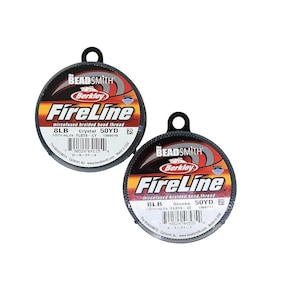 May include: Two spools of Berkley FireLine microfused braided bead thread. The spools are black with red and white text. The left spool is labelled "Crystal" and the right spool is labelled "Smoke". Both spools are 8lb test and 50 yards.