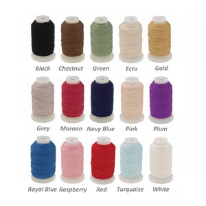 May include: A selection of thread spools in a range of colours: black, chestnut, green, ecru, gold, grey, maroon, navy blue, pink, plum, royal blue, raspberry, red, turquoise, and white. Each spool is labelled with its colour.
