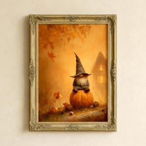Puede incluir: Una obra de arte enmarcada con temática otoñal. Presenta un gnomo con un sombrero puntiagudo, sentado sobre una gran calabaza. El fondo muestra una casa con ventanas iluminadas y hojas cayendo, todo en tonos cálidos naranja y marrón.