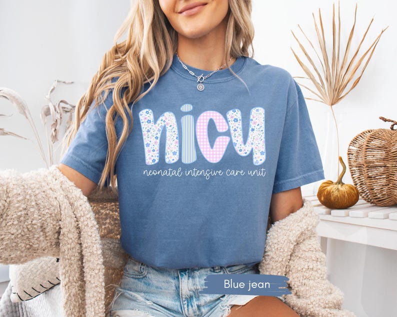 Peut inclure: T-shirt bleu jean avec les lettres "NICU" dans un motif floral et vichy. Les mots "neonatal intensive care unit" sont imprim&eacute;s en dessous. Le t-shirt &agrave; manches courtes a une coupe d&eacute;contract&eacute;e.