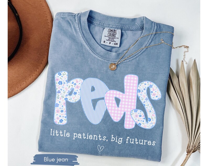 blue Comfort Colors® shirt with pastel floral and gingham “peds” design and phrase “little patients, big futures,” styled with necklace