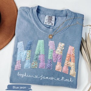 Puede incluir: Camiseta Comfort Colors azul vaquero con la palabra "MAMA" en letras de patchwork. Los nombres "Sophia", "James" y "Noah" est&aacute;n escritos debajo. Un collar de oro est&aacute; sobre la camiseta.