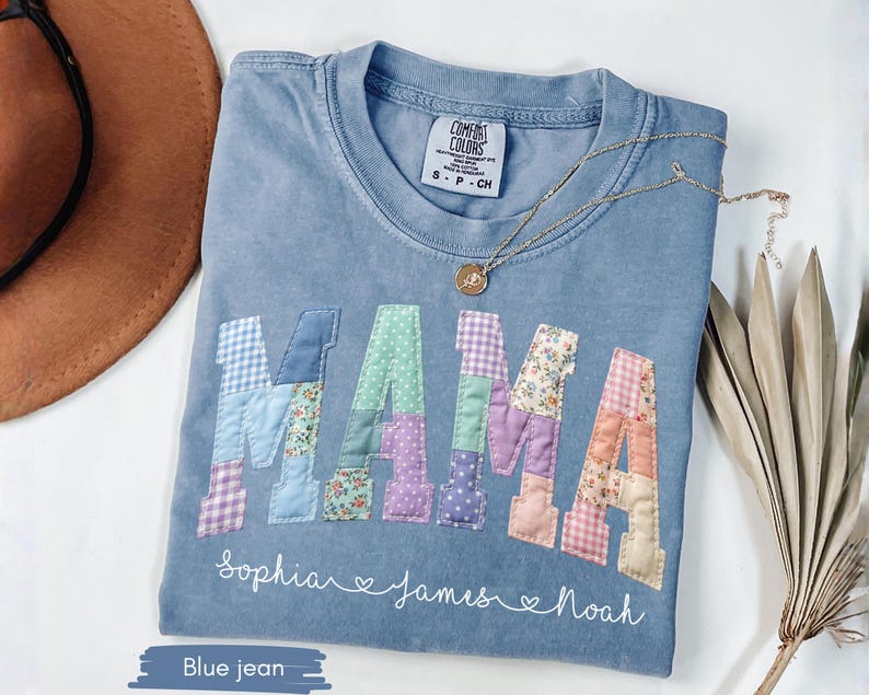 Puede incluir: Camiseta Comfort Colors azul vaquero con la palabra "MAMA" en letras de patchwork. Los nombres "Sophia", "James" y "Noah" est&aacute;n escritos debajo. Un collar de oro est&aacute; sobre la camiseta.