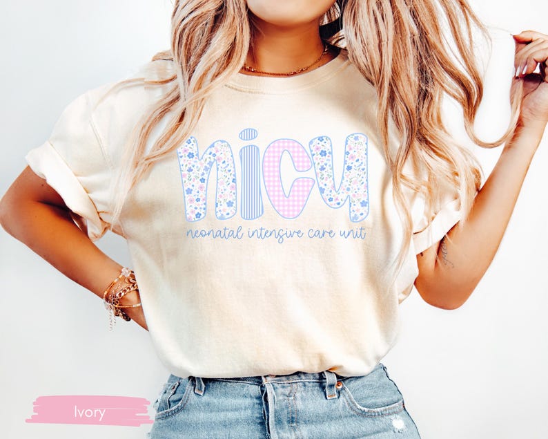 Peut inclure: T-shirt ivoire avec le mot "NICU" en grandes lettres color&eacute;es. Les lettres sont d&eacute;cor&eacute;es de motifs floraux, de rayures et de carreaux vichy. En dessous, le texte "neonatal intensive care unit".