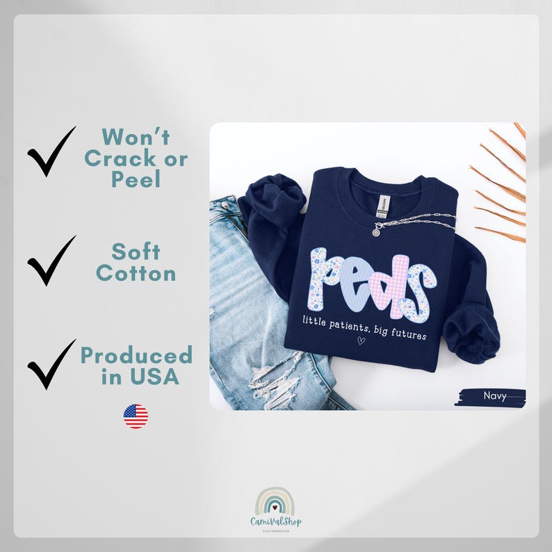 May include: Navy blue sweatshirt with the word "peds" in a floral and checkered design. The text "little patients, big futures" is below the word "peds". The sweatshirt is paired with blue jeans. The image also includes text that says "Won't Crack or Peel", "Soft Cotton", and "Produced in USA".