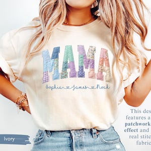 Puede incluir: Camiseta color marfil con la palabra "MAMA" en un dise&ntilde;o de estampado patchwork. Los nombres "Sophia", "James" y "Noah" est&aacute;n impresos debajo. El dise&ntilde;o presenta un efecto de impresi&oacute;n patchwork.