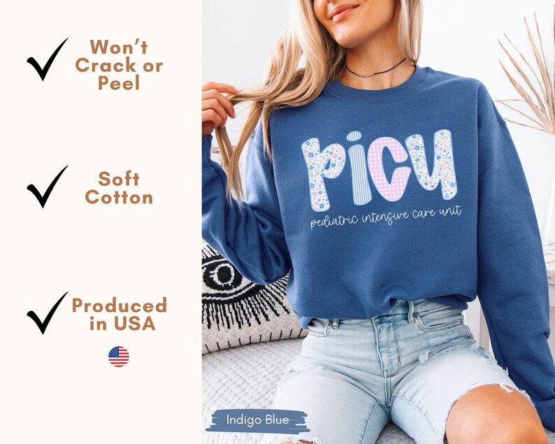 May include: Indigo blue sweatshirt with the word "PICU" in a floral and gingham pattern. The text "pediatric intensive care unit" is below the word. The sweatshirt is made of soft cotton and produced in the USA.