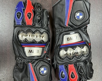 Könnte beinhalten: Ein Paar schwarze Leder-Motorradhandschuhe mit roten, blauen und weißen Akzenten. Die Handschuhe haben ein BMW-Logo und das Wort "motorrad" darauf.