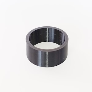 Peut inclure: Un objet cylindrique noir avec un centre creux. L'objet a une finition lisse et mate. La forme est un simple anneau, adapté à diverses applications. Il est probablement fait d'un matériau solide.