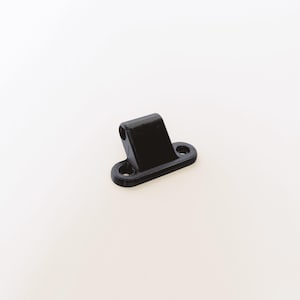 May include: A small, black, angled bracket with two mounting holes and a cylindrical opening. The bracket is made of a solid, matte material and is designed for structural support or attachment.