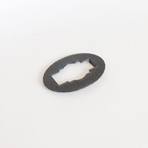 May include: A gray oval-shaped plastic piece with a rectangular cutout in the center. The cutout has a slightly raised border.