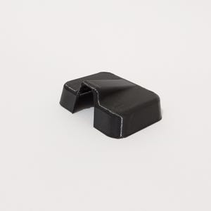 Puede incluir: Un tope de puerta de plástico negro con una parte superior curva y una base rectangular. El tope de puerta tiene una pequeña abertura en el centro.