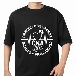 May include: Black t-shirt with a white graphic. The graphic includes a heart, a nurse's hat, and the words "CNA Life" in a circular design. The circle is surrounded by the words "Patience, Love, Courage, Compassion, Caffeine."