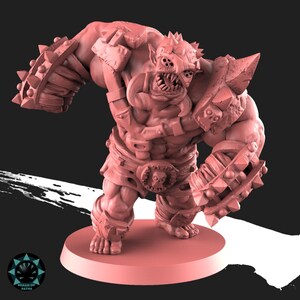 Peut inclure: Figurine miniature rose repr&eacute;sentant une cr&eacute;ature monstrueuse muscl&eacute;e, avec une armure &agrave; pointes. La figurine a une ceinture avec une boucle en forme de cr&acirc;ne, plusieurs yeux et des dents ac&eacute;r&eacute;es. Elle se tient sur une base circulaire.