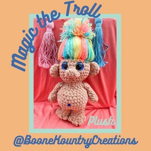 May include: A handmade crochet troll doll with a rainbow-colored hairpiece and large blue eyes. The doll has a tan body and is labeled "Magic the Troll Plush" with the seller's social media handle.
