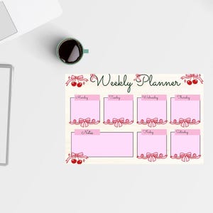 Puede incluir: Un planificador semanal con casillas rosas para cada día, adornadas con lazos y cerezas rojas. Las palabras "Weekly Planner" están escritas en cursiva. También se ven un cuaderno, una taza de café y una tetera.
