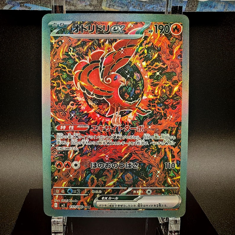 May include: A holographic trading card featuring a red and black phoenix-like creature with the Japanese text "オドリドリEX". The card has a green border and includes Japanese text and symbols, with a HP of 190.