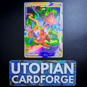 May include: A holographic Rayquaza and Deoxys Legend trading card featuring a green dragon-like creature and an orange humanoid figure. Below the card is a rectangular label with a blue galaxy pattern and the white text UTOPIAN CARDFORGE.