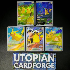 May include: Five collectible trading cards featuring Pikachu characters. The cards have colorful illustrations with Japanese text and various point values. The cards are displayed on a dark surface with a "UTOPIAN CARDFORGE" sticker.