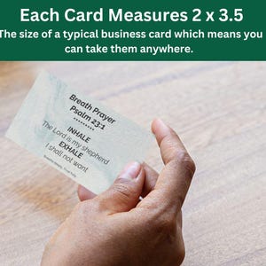 May include: A business card held in a hand, featuring the text "Breath Prayer Psalm 23:1" with "INHALE" and "EXHALE" instructions. The card measures 2 x 3.5 inches. The background includes a wooden surface and a glass vase.