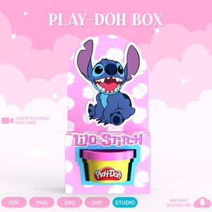 Puede incluir: Una caja rosa de Play-Doh con un gráfico del personaje azul Stitch de Lilo & Stitch. La caja tiene una ventana recortada que muestra un recipiente amarillo de Play-Doh con tapa rosa. El texto incluye PLAY-DOH BOX y Lilo & Stitch.
