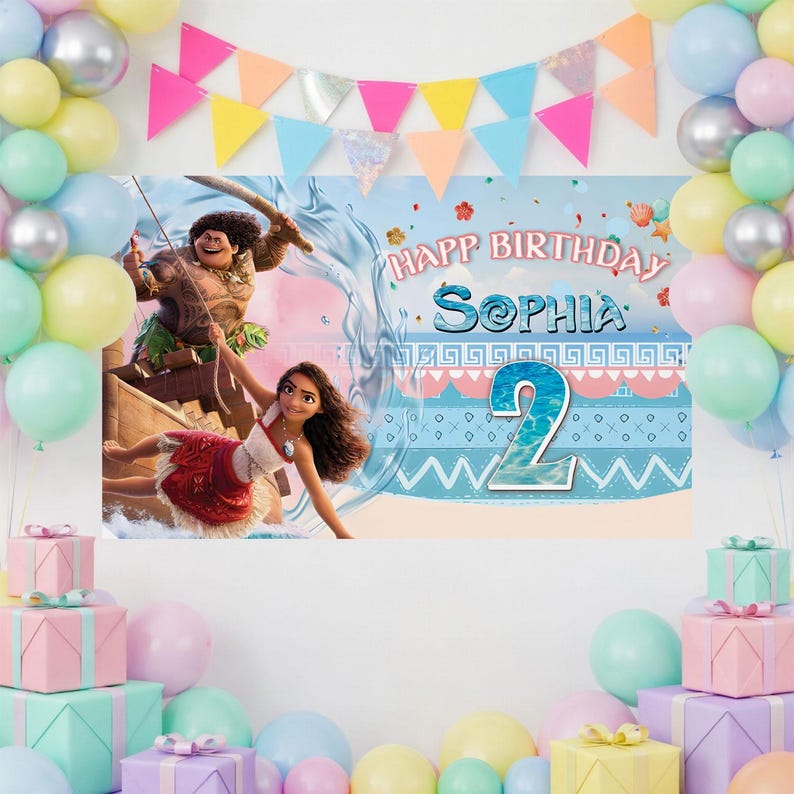 May include: A rectangular birthday backdrop featuring Moana and Maui characters, with the text "HAPPY BIRTHDAY SOPHIA" and the number "2" displayed prominently. The scene is framed by a colorful balloon arch in pastel shades and gift boxes.