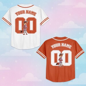 May include: Two short-sleeve baseball jerseys, one white and one orange, each featuring a cartoon fox character, the text "YOUR NAME" in an arched font, and the number "00" on the back. Both jerseys have striped trim on the sleeves and collar.