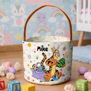 May include: An Easter basket with a brown handle and a colorful design featuring the character Tigger holding an Easter egg. The name "Mike" is printed on the basket. The basket is surrounded by Easter-themed decorations.