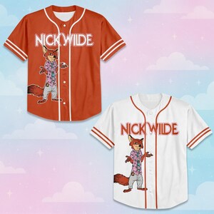 May include: Two short-sleeve button-down baseball jerseys, one in orange and one in white. Both feature the text NICK WILDE in a stylized font above a graphic of a cartoon fox wearing a pink patterned shirt and grey pants, with white striped trim.
