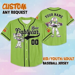May include: A lime green baseball jersey featuring Buzz Lightyear from Toy Story. The front displays "Buzz Lightyear" in black script, the number "00", and a Buzz Lightyear graphic. The back has "YOUR NAME" and another Buzz Lightyear graphic. Text at the top says "CUSTOM ANY REQUEST".