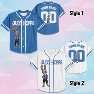 May include: Two baseball jerseys featuring Judy Hopps graphics. Style 1 is blue with white trim, while Style 2 is white with blue trim. Both display the text Judy Hopps on the front, and Your Name with the number 00 on the back.