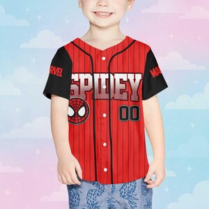 Puede incluir: Camiseta de b&eacute;isbol roja y negra con la palabra "SPIDEY" en letras blancas. La camiseta presenta un logotipo de Spider-Man y el n&uacute;mero "00". Las mangas son negras y la camiseta tiene una parte delantera abotonada.