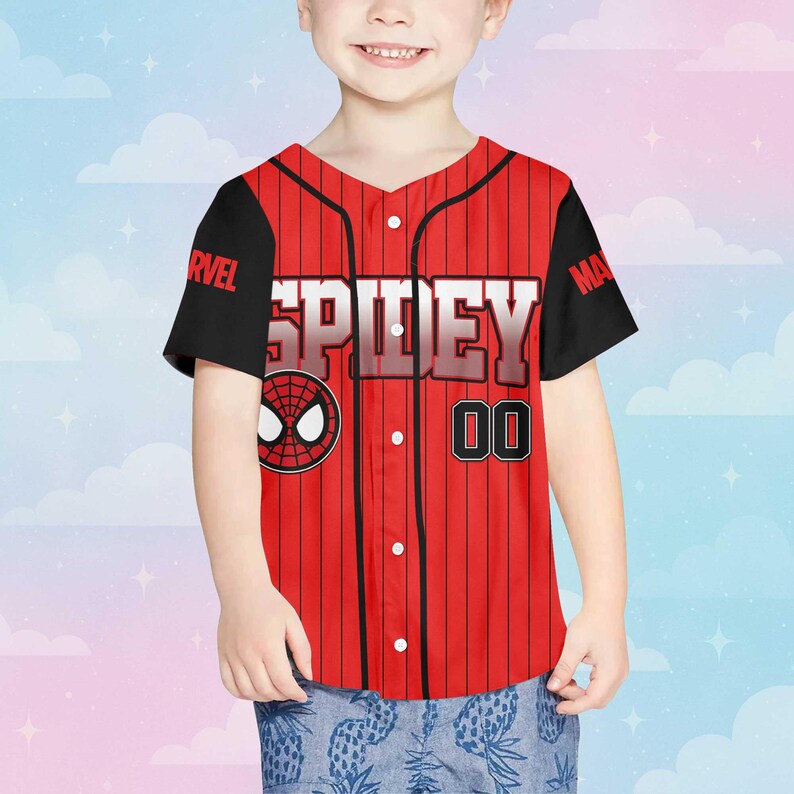 Puede incluir: Camiseta de b&eacute;isbol roja y negra con la palabra "SPIDEY" en letras blancas. La camiseta presenta un logotipo de Spider-Man y el n&uacute;mero "00". Las mangas son negras y la camiseta tiene una parte delantera abotonada.