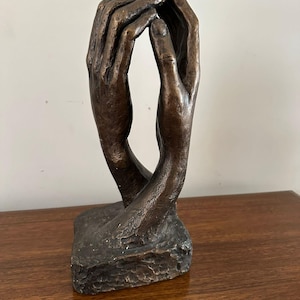 Op de afbeelding: Een witte keramische mok met een zwarte handgreep en de tekst "But First, Coffee" in een handschriftstijl. De mok staat op een wit oppervlak. De mok is ongeveer 10 cm hoog.