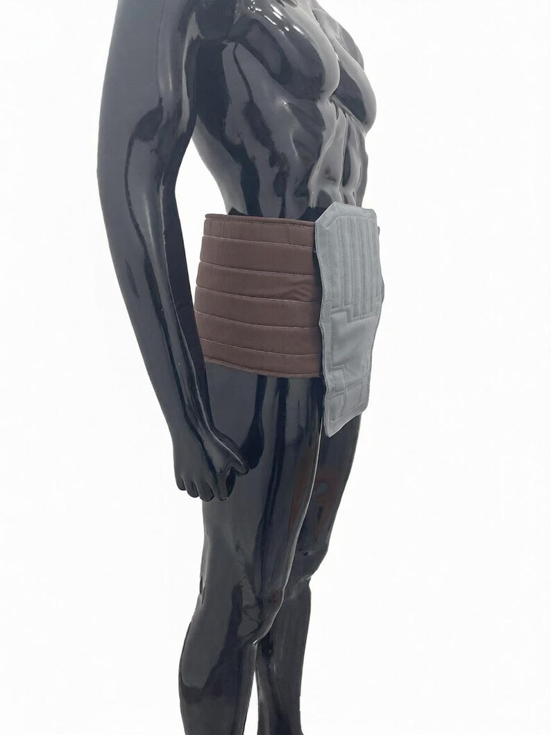 Puede incluir: Una faja de soporte abdominal marr&oacute;n y gris. La faja est&aacute; hecha de un material suave y acolchado y presenta una secci&oacute;n marr&oacute;n acanalada que se envuelve alrededor de la cintura. Una secci&oacute;n rectangular gris est&aacute; unida en la parte delantera.