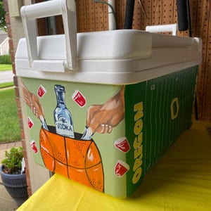 May include: A white ceramic mug with a black handle and the text "But First, Coffee" in a bold, black font. The mug is set against a neutral background, highlighting its simple design.