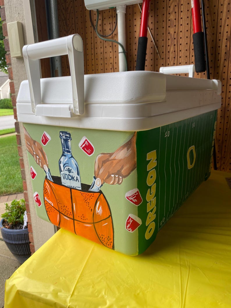 May include: A white ceramic mug with a black handle and the text "But First, Coffee" in a bold, black font. The mug is set against a neutral background, highlighting its simple design.