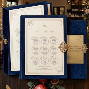 Könnte beinhalten: Elegante Eventdekoration mit Tischordnung, goldgeränderten Gläsern und verziertem Besteck. Die Tischordnung befindet sich in einem blauen Samtrahmen mit goldenen Akzenten. Garnierungen und eine dekorative Schale sind ebenfalls vorhanden.