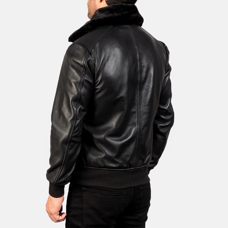 May include: A black leather bomber jacket with a faux fur collar. The jacket has a ribbed knit collar, cuffs, and waistband.