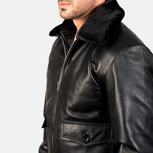 May include: A black leather bomber jacket with a faux fur collar. The jacket has a zipper closure and a flap pocket on the left side.